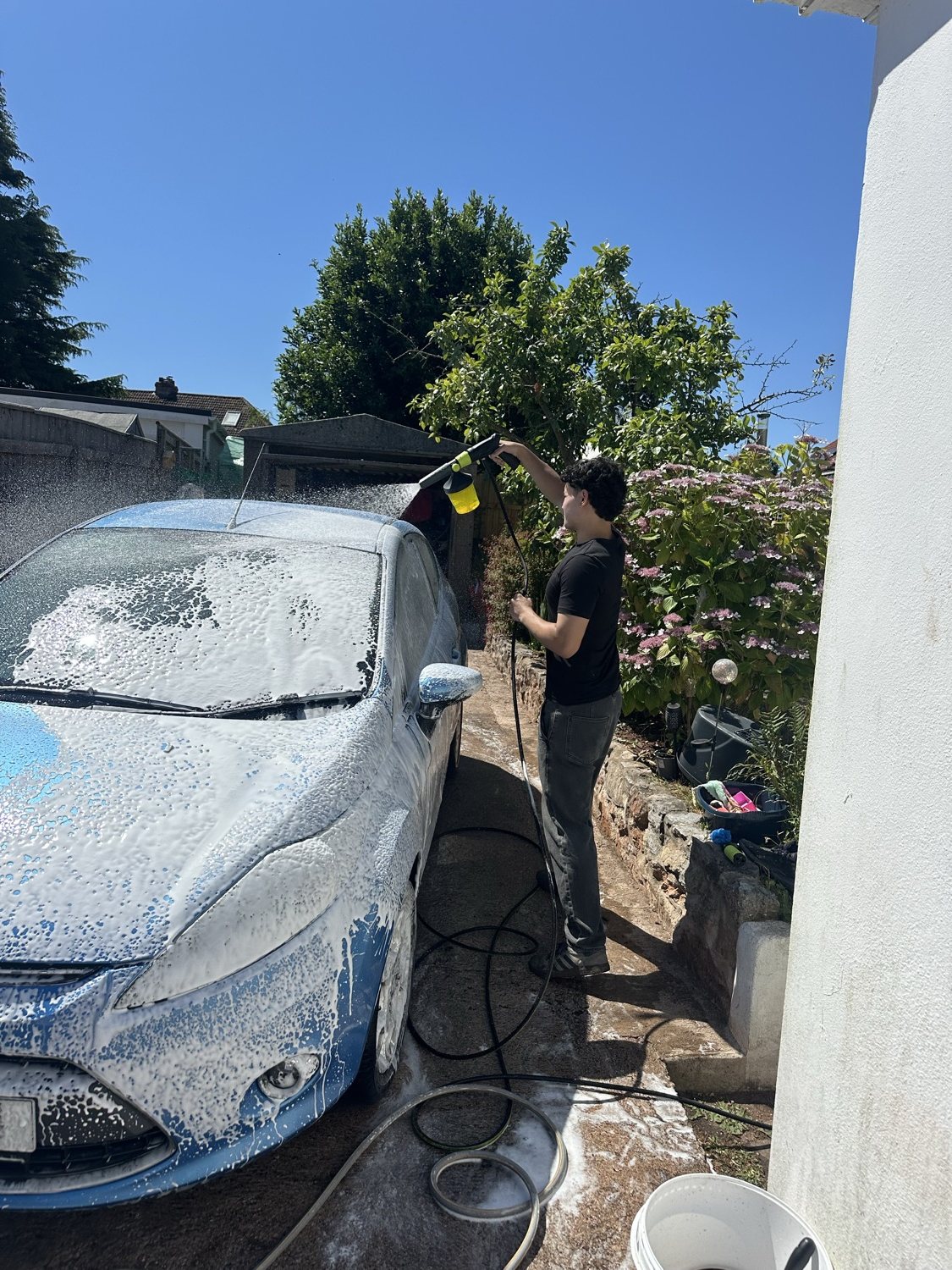 T&B Detailing washing a car with snow foam on a sunny driveway