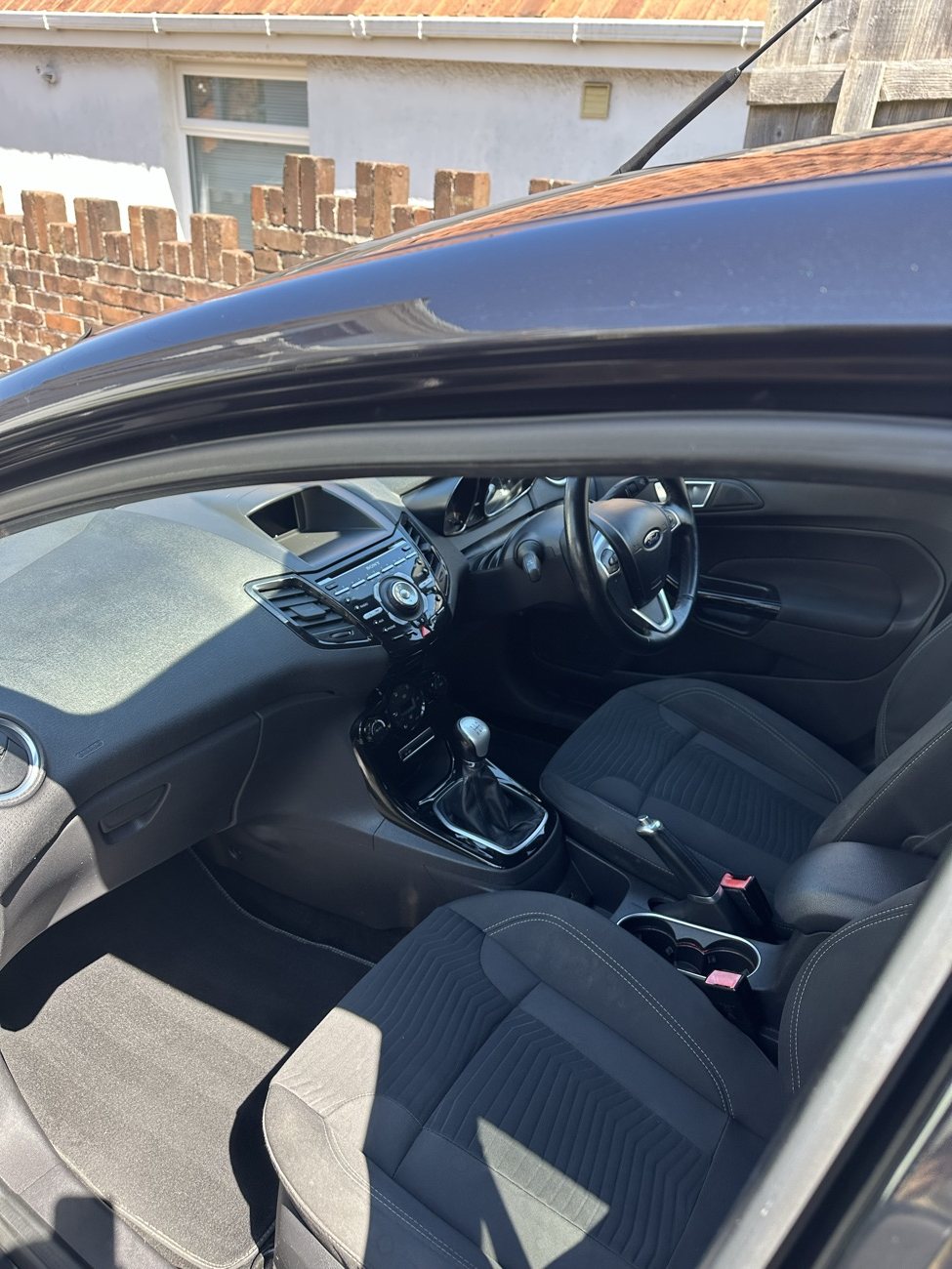 Black Ford Fiesta front cabin after detailing, dashboard and seats cleaned